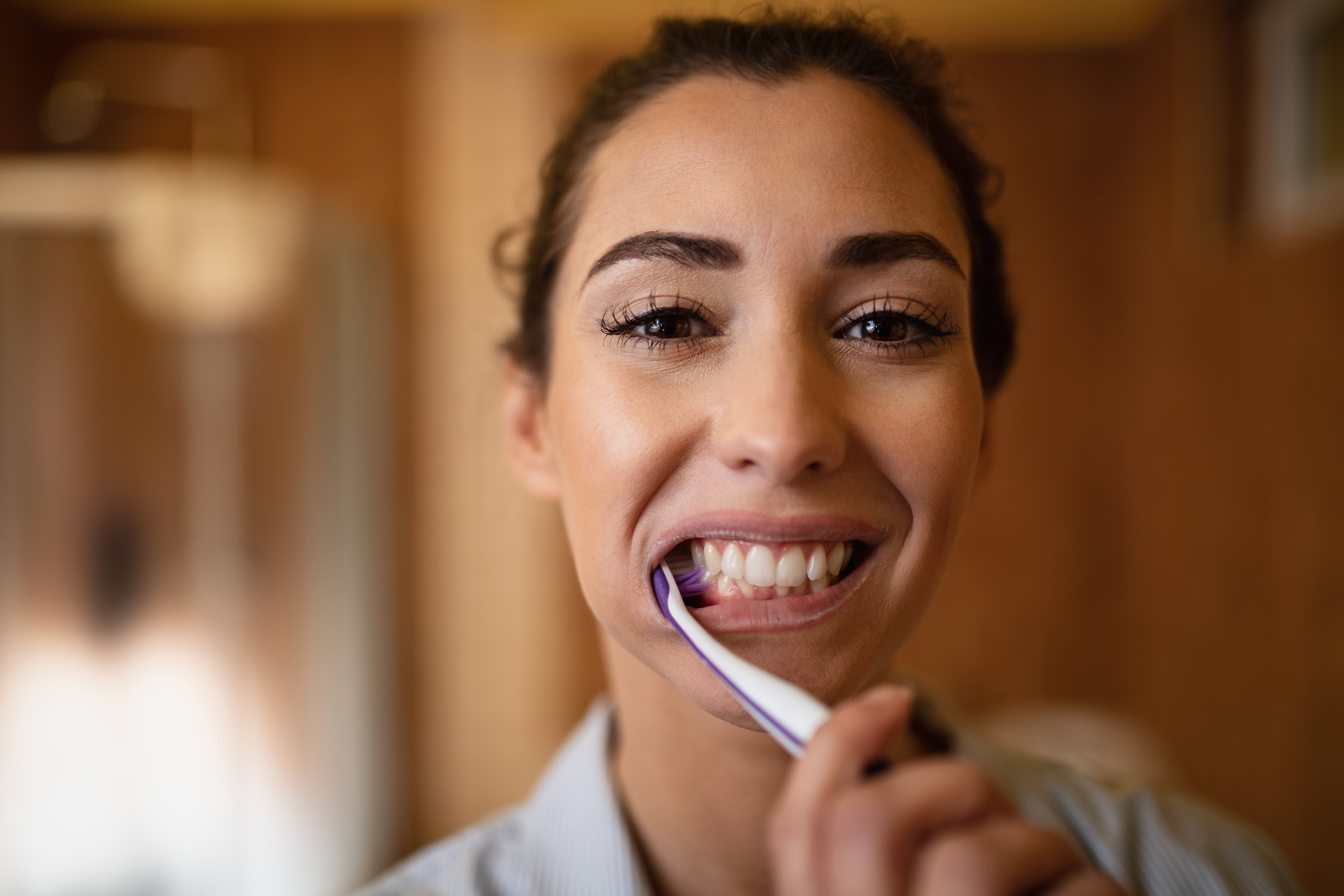 closeup-beautiful-woman-brushing-teeth-bathroom